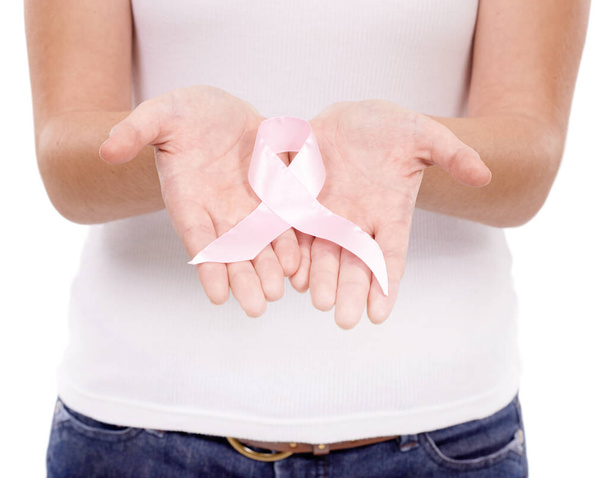 Ένας σκοπός που αξίζει να υποστηριχθεί. Μια νεαρή γυναίκα με μια κορδέλα καρκίνου του μαστού απομονωμένη σε λευκό. - Φωτογραφία, εικόνα