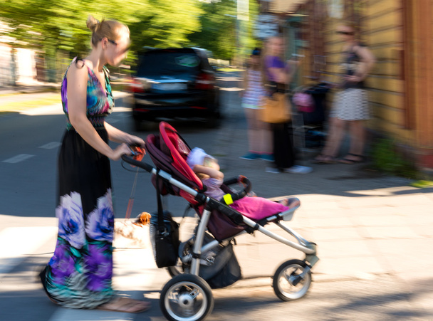 Moeder met peuter kind in de wandelwagen - Foto, afbeelding