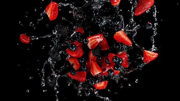 Freeze motion of berries in water splash. Isolated on Black Background. - Foto, Imagem