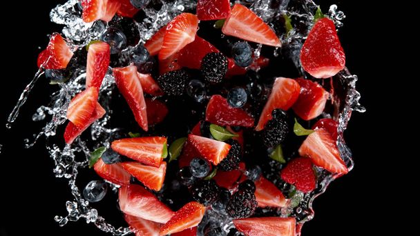Freeze motion of berries in water splash. Isolated on Black Background. - Fotó, kép