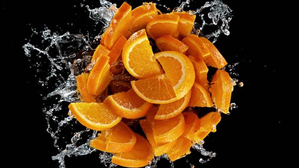 Freeze motion of sliced oranges in water splash. Isolated on Black Background. - 写真・画像