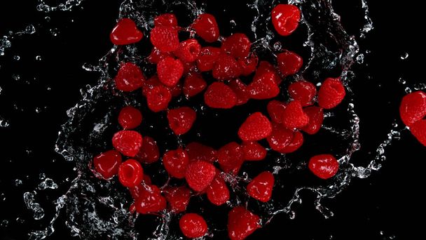 Freeze motion of raspberries in water splash. Isolated on Black Background. - Foto, imagen