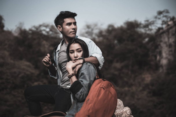 backpackers matkustaa turisteja aasialainen pari istuu kivi luonnollinen metsä backpacker pari käsite ja kuva tumma tyyli - Valokuva, kuva