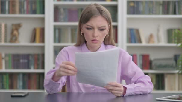 Žena rozrušená při čtení dokumentů v kanceláři - Záběry, video