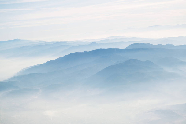 Vue des montagnes de l'izmir dans les nuages de l'avion. Teintes bleues. - Photo, image