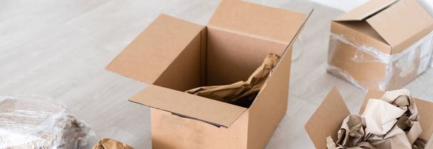 открыть коробку посылок на полу рядом с открытой дверью - Фото, изображение