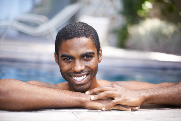 Abkühlung nach einem langen Tag. Porträt eines gutaussehenden jungen Mannes, der sich in einem Pool entspannt. - Foto, Bild
