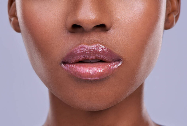 Lucious lips. Cropped shot of a young womans mouth against a purple background. - Photo, Image