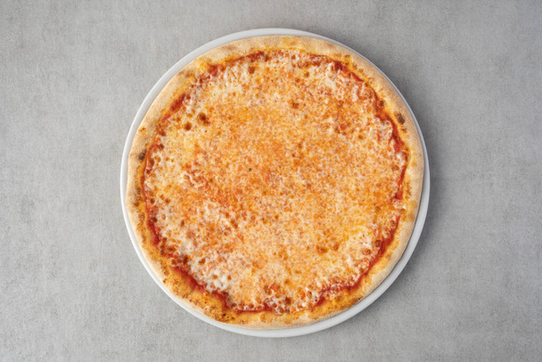 Margherita pizza na talerzu na szarym tle kamienia. Widok z góry - Zdjęcie, obraz