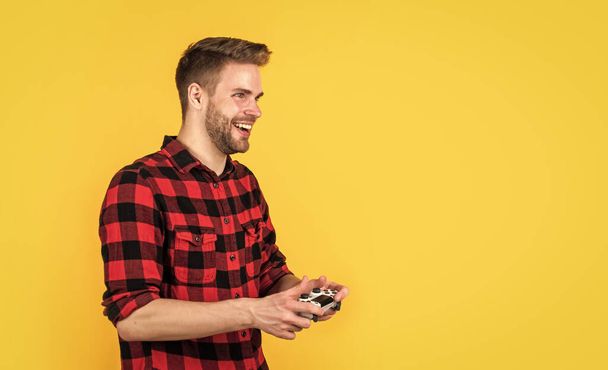 stylish guy with trendy hairstyle wear checkered shirt playing video game, fun - Фото, изображение