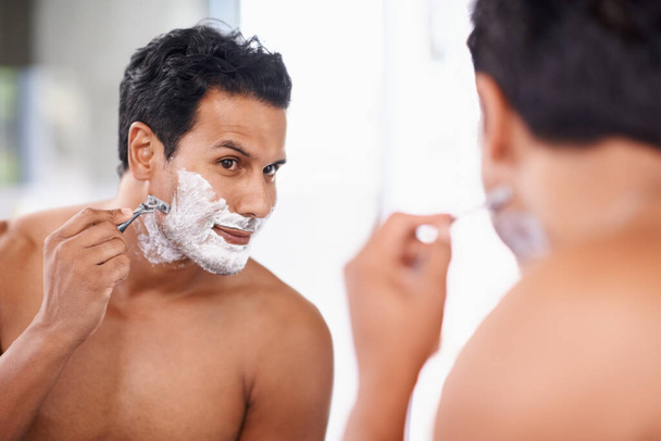 The ladies love a smooth face. A handsome young man shaving in the bathroom. - Foto, imagen