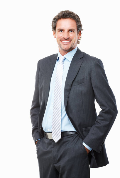 Hombre de negocios sonriente posando sobre fondo blanco. Retrato de hombre de negocios guapo de pie con las manos en los bolsillos sobre fondo blanco. - Foto, imagen