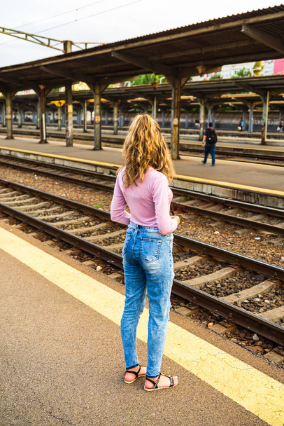 Młoda kobieta robi zdjęcia na dworcu kolejowym w Bukareszcie, Rumunia, 2022 - Zdjęcie, obraz