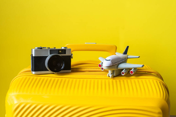 Suitcase, camera and plane. Vacation and travel concept - Photo, image