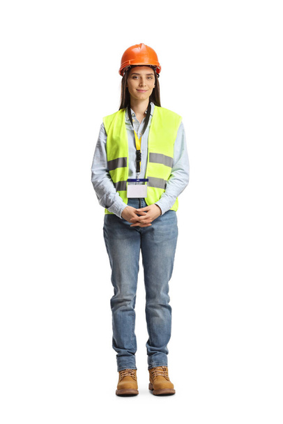 Full length portrait of a young female engineer with a safety vest and hardhat isolated on white background - Foto, afbeelding