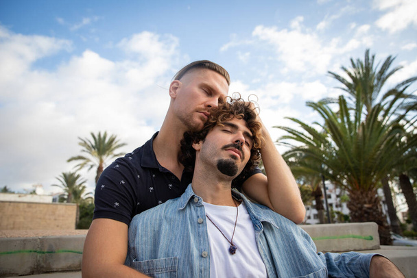 Два парня-гея обнимаются, закрывают глаза и любят друг друга. - Фото, изображение