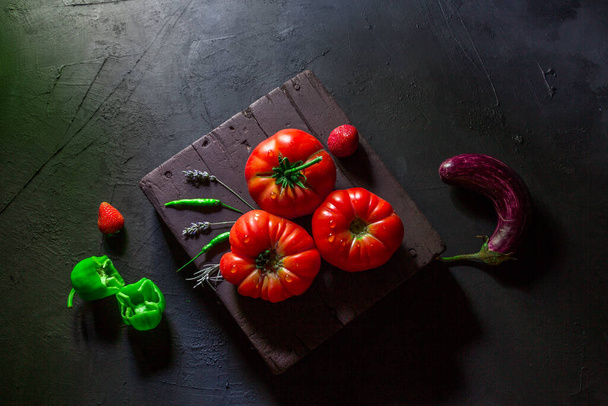 Pomidory strzał na czarnym tle w naturalnym świetle - Zdjęcie, obraz