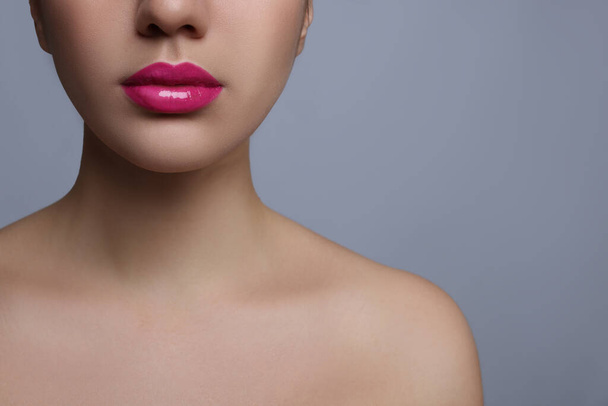 Closeup view of woman with beautiful full lips on grey background. Space for text - Zdjęcie, obraz