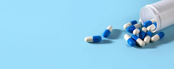 Banner con bottiglia di pillole colorate con sfondo blu. - Foto, immagini