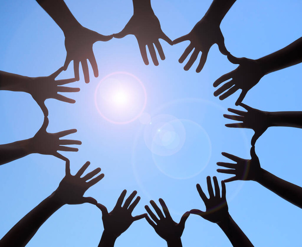 Joining together to form one. Shot of a group of hands spread out together in a circle. - Photo, image