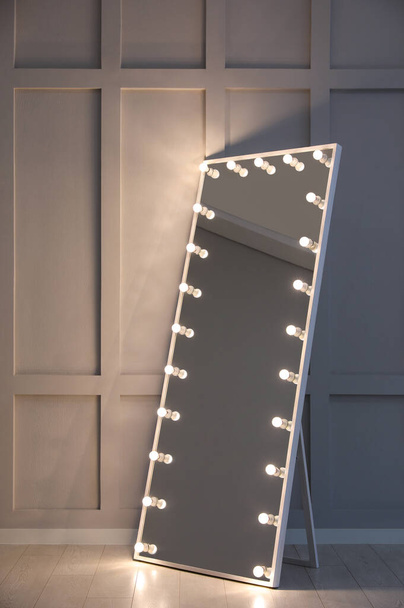 Modern mirror with light bulbs near molding wall in room - Photo, Image