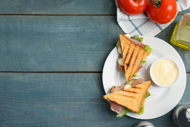 Delizioso panino con verdure, prosciutto e maionese servito su tavolo di legno azzurro, piatto. Spazio per testo - Foto, immagini