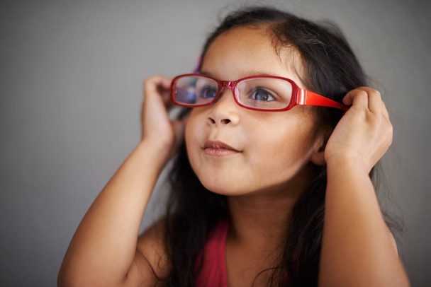 I think they suit me, dont you. Shot of a cute little girl trying on an adult pair of glasses. - Φωτογραφία, εικόνα