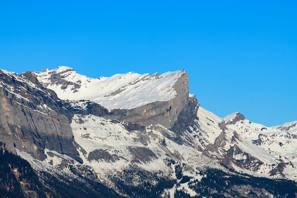 Deze landschapsfoto is genomen in Europa, in Frankrijk, Rhone Alpes, in Savoie, in de Alpen, in de winter. We zien La Chaine des Fiz, onder de zon. - Foto, afbeelding