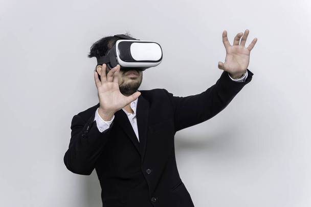 Portrait of young businessman wear virtual reality (VR) goggles on white background - Fotografie, Obrázek