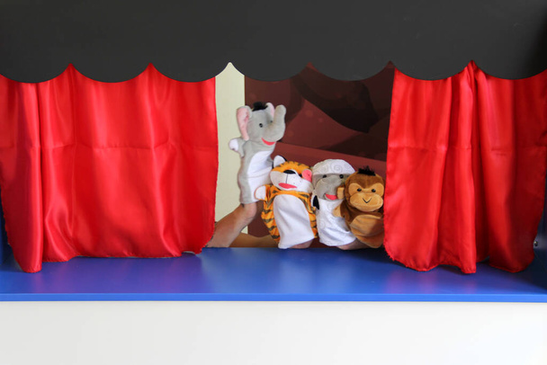 Die kulturelle und pädagogische Kinderaktivität des Guignol-Theaters erzählt eine Geschichte in einer kleinen Replik eines Theaters, in dem Puppen oder Handschuhpuppen ihre Hände bewegen - Foto, Bild