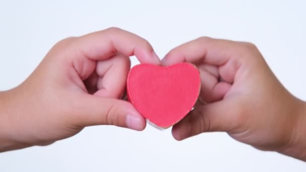 Klein meisje met een rood hart in haar hand. Concept voor liefdadigheid en gezondheid. Internationale dag van de cardiologie. - Video