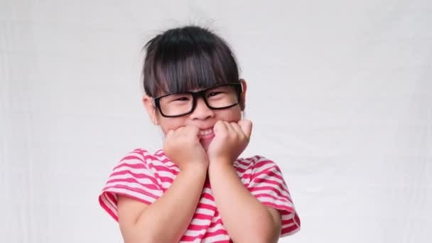 Aranyos kislány visel szemüveget, ő szép, bájos és élvezi a jó hangulatot fehér háttér stúdió. - Felvétel, videó