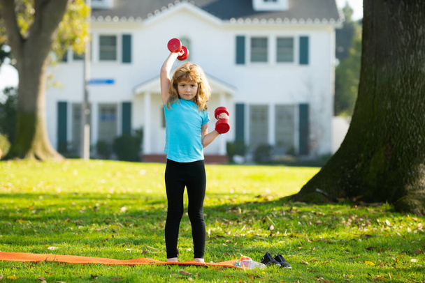 Children having workout. Sport kids activities outdoor. Child raising a dumbbell. - Фото, изображение