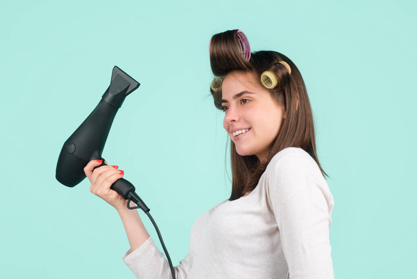 Woman with hair dryer isolated in studio. Beautiful girl with straight hair drying hair with professional hairdryer. - Valokuva, kuva
