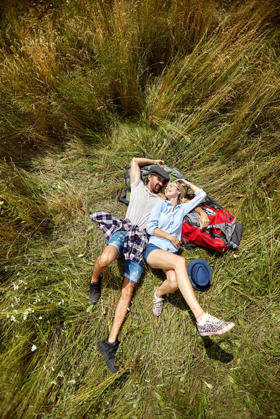 Loving embracing couple laying on grass and having fun in the nature together - Foto, Bild