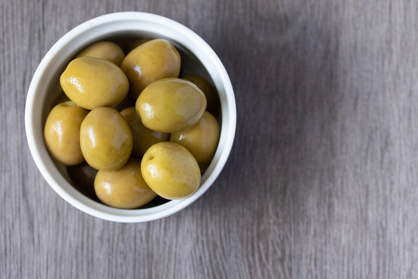 Мариновані зелені оливки в мисці
 - Фото, зображення