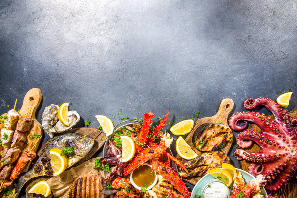 Assortment various barbecue Mediterranean grill food - fish, octopus, shrimp, crab, seafood, mussels, summer diet bbq party fest, with kebab, sauces, black concrete background, above copy space - Photo, Image