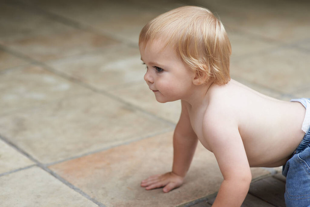 Crawling around the house. A sweet little baby boy crawling outside. - Fotó, kép