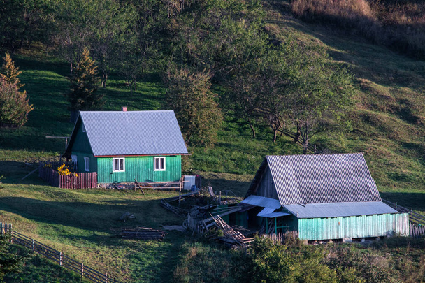 Nahaufnahme alter traditioneller Häuser auf den Hügeln, die von der Sonne getroffen werden in Lupcina, Rumänien - Foto, Bild
