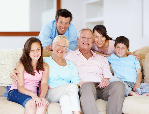 Együtt éljük le az életünket - Családi támogatás. Három generációnyi család ül együtt szeretettel a kanapén.. - Fotó, kép