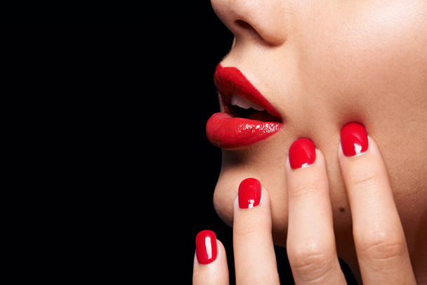 A splash of COLOR. A cropped studio shot of a beautiful model wearing red lipstick and nailpolish. - Photo, Image