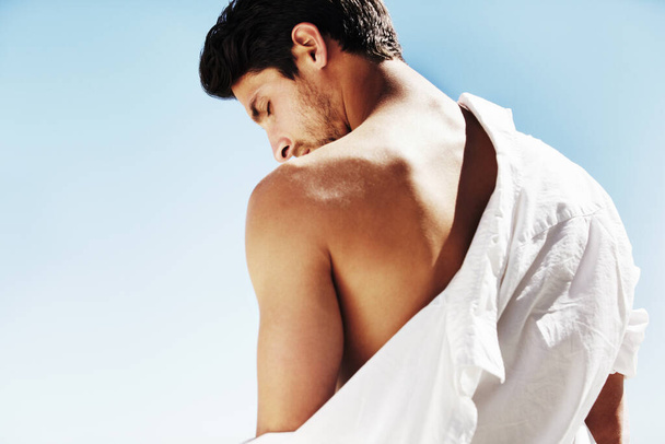 Laisse le soleil se laver sur moi. Un mystérieux mâle attrayant enlevant sa chemise blanche au soleil d'été - Copyspace. - Photo, image