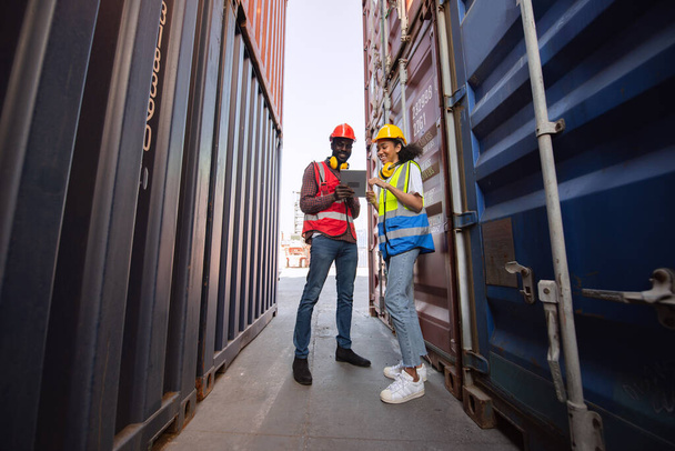 Happy two African american male and female worker using tablet and checking control loading freight containers from Cargo freight ship for import export. - Zdjęcie, obraz