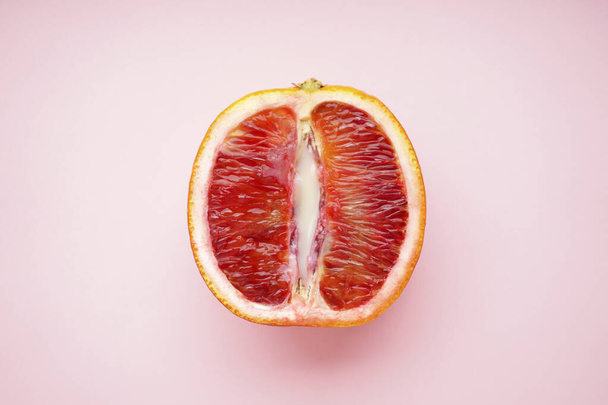 Sangre jugosa de naranja y leche condensada sobre un fondo rosa. Vista superior. Concepto de sexo 18+ - Foto, imagen