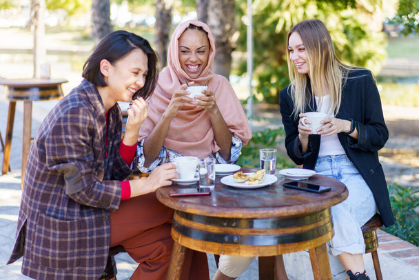 Riendo diversas mujeres tomando un descanso de café en la cafetería al aire libre - Foto, Imagen