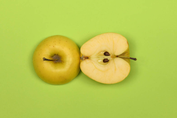 Κίτρινο μήλο απομονωμένο στο πράσινο. Φωτογραφία υψηλής ανάλυσης. Πλήρες βάθος πεδίου. - Φωτογραφία, εικόνα