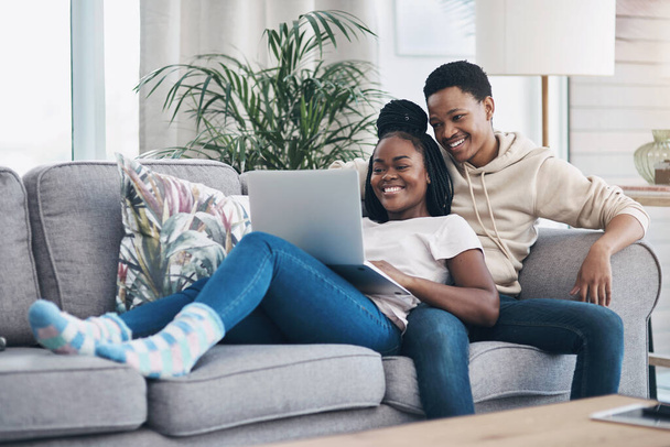 Nichts sagt mehr über Romantik aus als ein gemütliches Wochenende zu Hause. Aufnahme eines jungen Paares mit einem Laptop beim Entspannen auf dem heimischen Sofa. - Foto, Bild