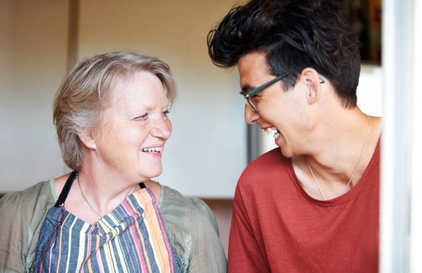 Theyve got a similar sense of humor - Mother and son. Young guy sharing a joke with his mom at home. - Photo, Image