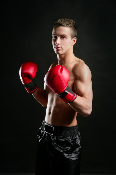 Young shaped man boxing, studio shot - Fotó, kép