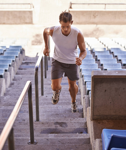 Sie müssen hart arbeiten, um zu gewinnen. Aufnahme eines Athleten, der im Rahmen seines Trainings eine Treppe hochläuft. - Foto, Bild